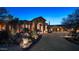 Grand home exterior with a large driveway and desert landscaping at night at 29600 N 106Th N Pl, Scottsdale, AZ 85262