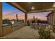 Covered outdoor kitchen with built-in grill and seating area at 29600 N 106Th N Pl, Scottsdale, AZ 85262