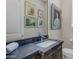 Elegant powder room with dark countertop and frameless mirror at 29600 N 106Th N Pl, Scottsdale, AZ 85262