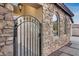 Close up of a black wrought iron gate leading to the house entrance at 29762 N 69Th Ln, Peoria, AZ 85383