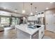 Modern kitchen with white cabinets, island with seating, and views to Gathering room at 29762 N 69Th Ln, Peoria, AZ 85383