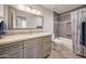 Updated bathroom with gray tile, a vanity with quartz countertop, and a bathtub at 3439 E Topeka Dr, Phoenix, AZ 85050