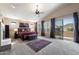 Bright and airy bedroom boasts a ceiling fan, balcony access, and a decorative rug with neutral carpet flooring at 3652 N Sonoran Hts, Mesa, AZ 85207