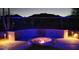 Outdoor fire pit surrounded by built-in seating with mountain views and decorative outdoor lighting at 3652 N Sonoran Hts, Mesa, AZ 85207