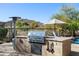 Outdoor built-in grill and counter space offer plenty of room for food preparation and entertaining by the pool at 3652 N Sonoran Hts, Mesa, AZ 85207