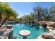 Custom pool features natural rock waterfall, mature palms, and a swim up table perfect for entertaining at 3652 N Sonoran Hts, Mesa, AZ 85207