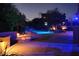 Inviting backyard pool and spa at twilight, featuring rock waterfall, lush plants, and a cozy fire pit at 3652 N Sonoran Hts, Mesa, AZ 85207