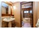 Bathroom with pedestal sink, bathtub and decorative mirror at 36601 N Mule Train Rd # B40, Carefree, AZ 85377