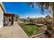 Landscaped backyard features a fire pit, patio, green grass, and shade trees for outdoor enjoyment at 3791 E Vista Grande Dr, San Tan Valley, AZ 85140