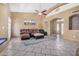 Spacious living room features a ceiling fan, tile floors, a brown sofa and beautiful wall art at 3791 E Vista Grande Dr, San Tan Valley, AZ 85140