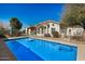 Backyard view of a beautiful home featuring a pool with a diving board and mature trees at 3791 E Vista Grande Dr, San Tan Valley, AZ 85140