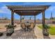 Relaxing backyard patio with pergola, seating, and built-in grill at 42157 W Cribbage Rd, Maricopa, AZ 85138