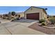 House exterior showcasing a red garage door and drought-tolerant landscaping at 42157 W Cribbage Rd, Maricopa, AZ 85138