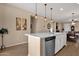 Kitchen island with sink, dishwasher, and view into dining area at 42157 W Cribbage Rd, Maricopa, AZ 85138