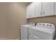 Laundry room with washer and dryer, and overhead cabinets at 42157 W Cribbage Rd, Maricopa, AZ 85138