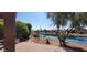 Scenic backyard with a waterway, lush landscaping, and a patio area at 42621 W Heavenly Pl, Maricopa, AZ 85138