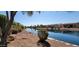 Backyard waterfront view features mature trees and landscaping at 42621 W Heavenly Pl, Maricopa, AZ 85138