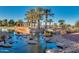 Resort-style pool with a relaxing waterfall and palm trees at 42621 W Heavenly Pl, Maricopa, AZ 85138