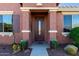 Attractive entryway with a dark wood door and planters at 42621 W Heavenly Pl, Maricopa, AZ 85138