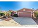 Front view of a one-story house with a two-car garage and drought-tolerant landscaping at 42621 W Heavenly Pl, Maricopa, AZ 85138