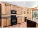 Well-equipped kitchen with black appliances and wood cabinets at 42621 W Heavenly Pl, Maricopa, AZ 85138