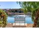 Serene lake view with a peaceful bench for relaxation at 42621 W Heavenly Pl, Maricopa, AZ 85138