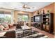 Living room with a large TV stand, comfortable seating, and a ceiling fan at 42621 W Heavenly Pl, Maricopa, AZ 85138