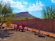 Desert backyard view with mature trees, a mountain in the distance, and two adirondack chairs ready for relaxation at 44311 N 1St Dr, New River, AZ 85087