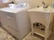 Modern laundry appliances with utility sink and faucet, marble tile floor at 44311 N 1St Dr, New River, AZ 85087