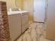 Bright laundry room with modern washer and dryer set on a marble tile floor at 44311 N 1St Dr, New River, AZ 85087