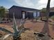 Exterior view of storage shed with metal siding, white door, and decorative desert landscaping at 44311 N 1St Dr, New River, AZ 85087