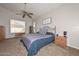 Comfortable bedroom featuring ceiling fan, carpet flooring, and a decorative wrought iron bed frame at 5184 W Del Rio St, Chandler, AZ 85226