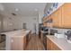 Well-lit kitchen with laminate counters, oak cabinets, stainless steel appliances, and access to living room at 5184 W Del Rio St, Chandler, AZ 85226