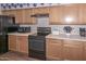 Functional kitchen featuring laminate counters, oak cabinets, and modern black appliances at 5184 W Del Rio St, Chandler, AZ 85226