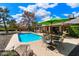 Inviting backyard oasis featuring a sparkling pool, patio furniture, and lush landscaping at 5213 W Soft Wind Dr, Glendale, AZ 85310