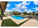 Modern backyard with a rectangular pool, artificial turf, and a covered patio at 5213 W Soft Wind Dr, Glendale, AZ 85310