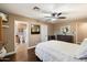 Cozy bedroom with hardwood floors, ceiling fan, and ensuite bathroom at 5213 W Soft Wind Dr, Glendale, AZ 85310