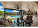 Inviting covered patio with ceiling fans, seating, and a view of the sparkling pool and landscaped backyard at 5213 W Soft Wind Dr, Glendale, AZ 85310