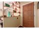 Entryway featuring decorative shelving, a brown paneled door, and tiled flooring at 6058 E El Paso St, Mesa, AZ 85205