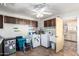 Well-lit laundry area features tile floor, adjacent to cabinets and a doorway leading to kitchen area at 6058 E El Paso St, Mesa, AZ 85205