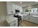 Updated kitchen featuring white cabinets, stainless steel appliances, and a quartz countertop at 7663 E Coolidge St, Scottsdale, AZ 85251