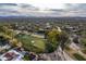 An aerial view of a golf course and the surrounding neighborhood, featuring homes and desert landscaping at 8119 E Foothills Dr, Scottsdale, AZ 85255