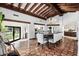 Elegant dining room with beam ceiling, tile floors, chandelier, and sliding glass doors to backyard at 8119 E Foothills Dr, Scottsdale, AZ 85255