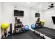 Bright home gym with full wall mirror, rubber flooring, mounted TVs and a variety of exercise equipment at 8119 E Foothills Dr, Scottsdale, AZ 85255