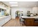 Bright kitchen with wood floors, white cabinets, marble countertops, and an eat-in island at 8119 E Foothills Dr, Scottsdale, AZ 85255