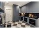 Spacious laundry area with gray cabinetry, marble counters, under-cabinet lighting, and checkered flooring at 8119 E Foothills Dr, Scottsdale, AZ 85255