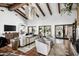 Bright living room with hardwood-look tile, exposed beams, and access to outdoor living spaces at 8119 E Foothills Dr, Scottsdale, AZ 85255