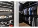 Custom closet with storage for shoes, clothes and accessories, wood floors, and dark built-in shelving with LED lights at 8119 E Foothills Dr, Scottsdale, AZ 85255