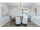 Elegant dining room with wood table, white chairs, and modern chandelier at 814 S 78Th St, Mesa, AZ 85208