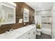 This bathroom features double sinks, wood accent wall, and modern finishes at 8312 E Mackenzie Dr, Scottsdale, AZ 85251